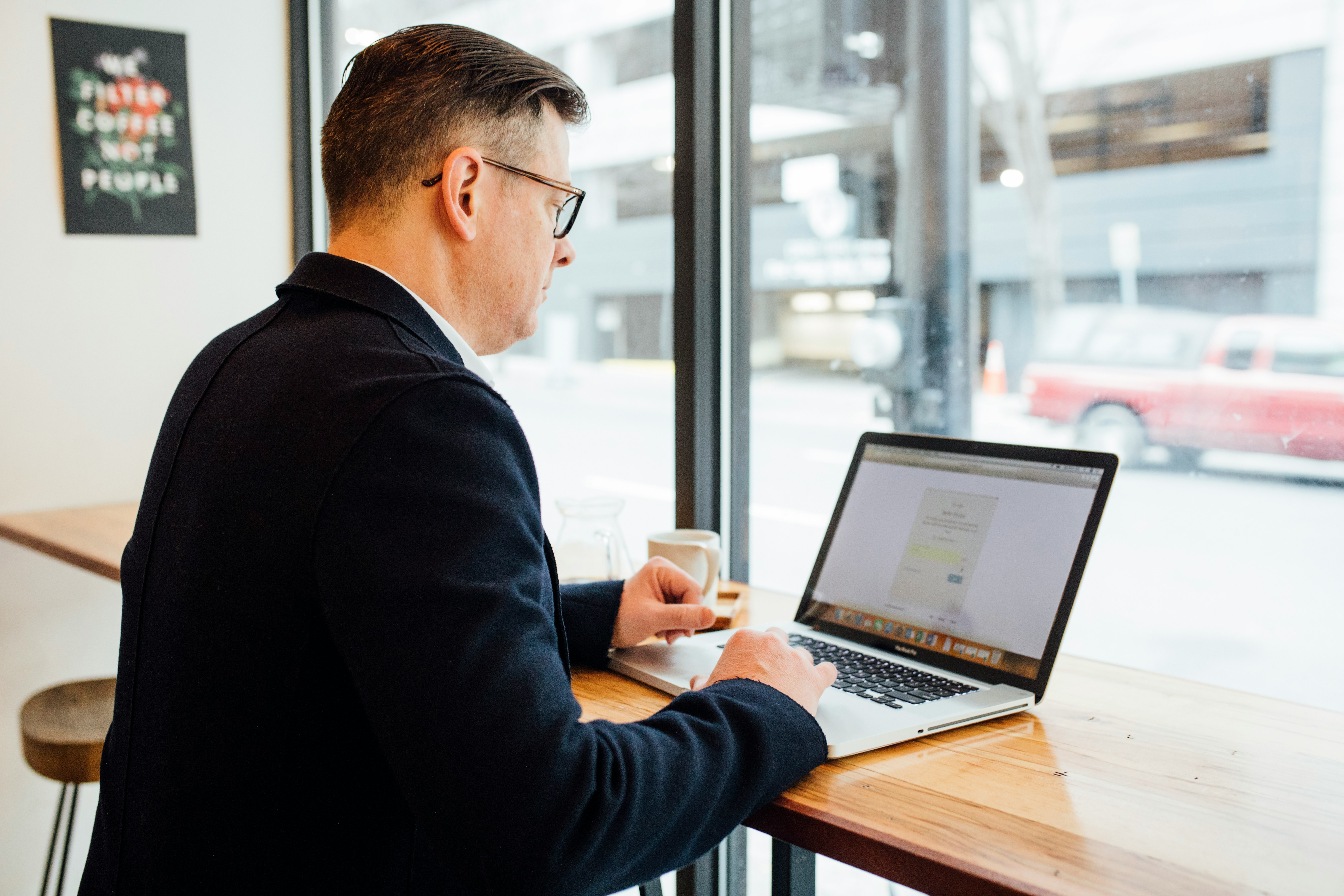 man wearing blue suit in front of MacBook Pro